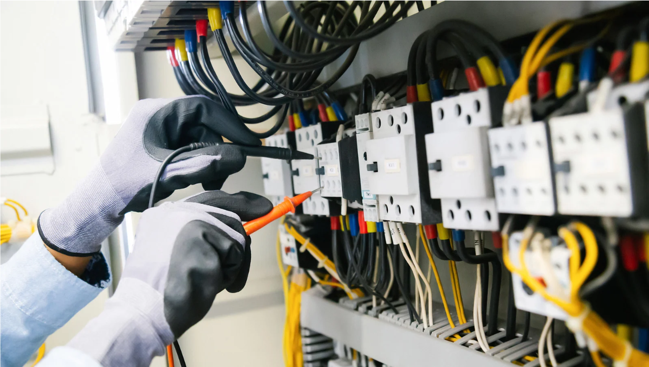Un operaio maneggia aree elettriche con guanti di protezione